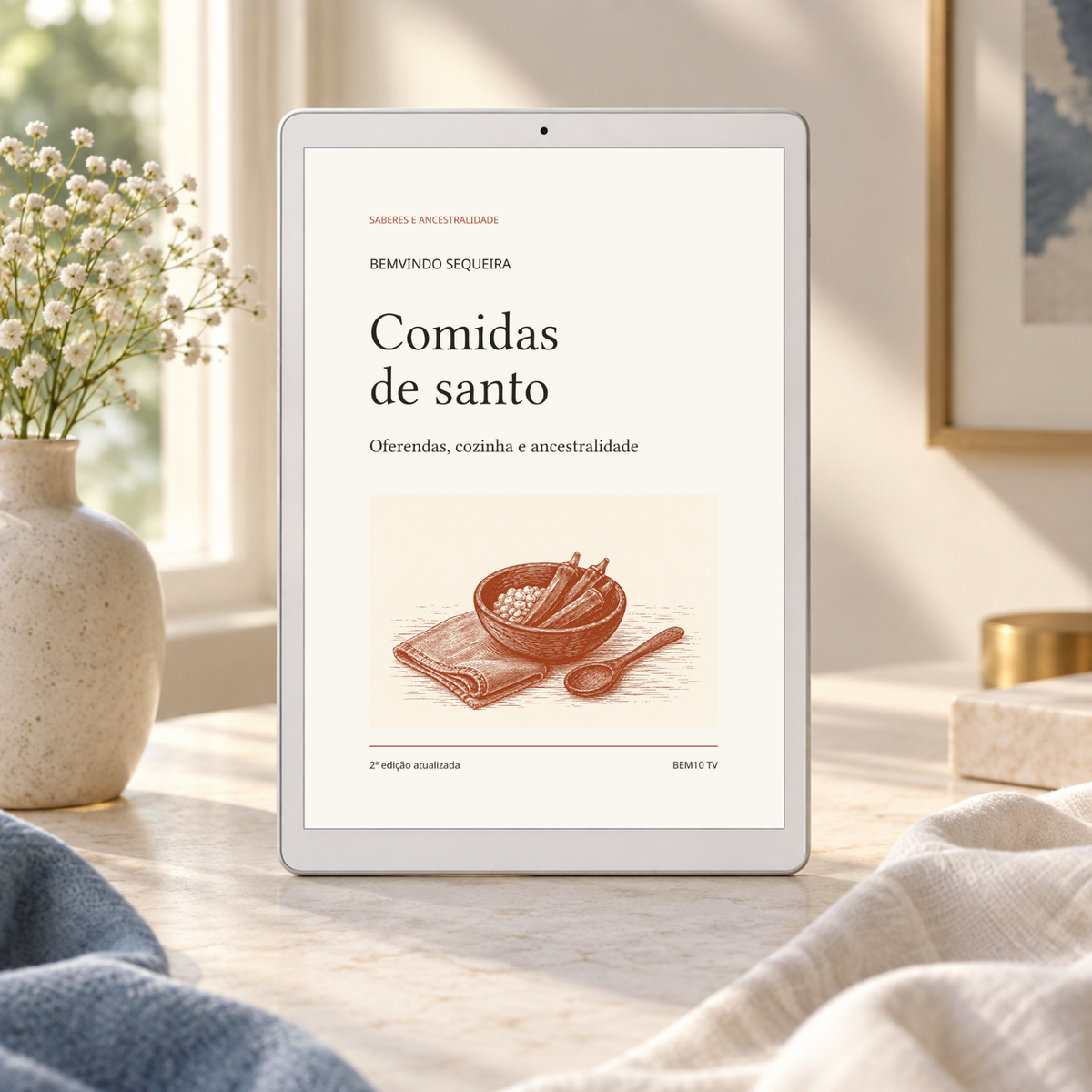 Comidas de santo — 2ª edição atualizada. Capa original em cenário ilustrativo de leitura digital; aparelho e objetos não incluídos.